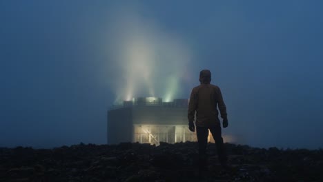 Island,-Blaue-Lagune,-Geothermisches-Kraftwerk-Svartsengi-Bei-Nacht,-Silhouette-Einer-Einzelnen-Person,-Die-Auf-Die-Fabrik-Zugeht,-Halbtotale
