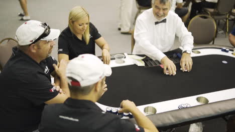 Wide-shot-of-a-group-of-people-at-a-poker-table