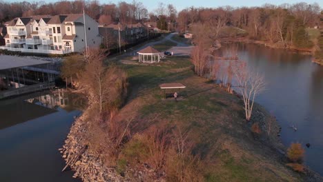 Aerial-drone-footage-flying-out-from-a-point-of-land-over-a-lake-with-nice-houses-and-boat-docks-at-sunset