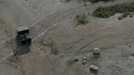 Buggy-drive-on-a-trail-in-a-desert-park,-aerial-footage-following-the-buggy