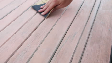 close-up-footage-of-a-male-hand-using-sand-paper-to-sand-a-wooden-door-or-table