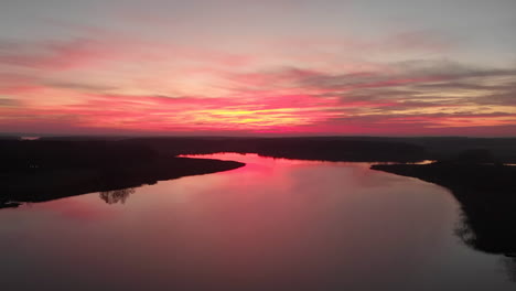 Drone-footage-flying-into-a-stunning-sunset-with-a-lake-underneath