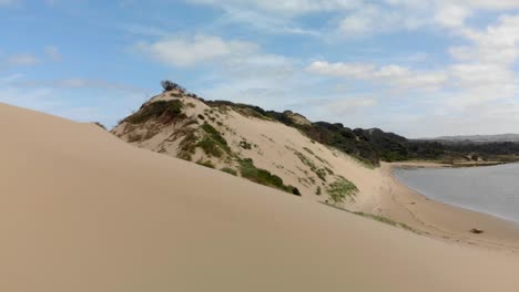 A-fast-moving-forward-aerial-of-a-river-mouth-system-and-moving-over-the-sand-dunes-to-reveal-the-ocean