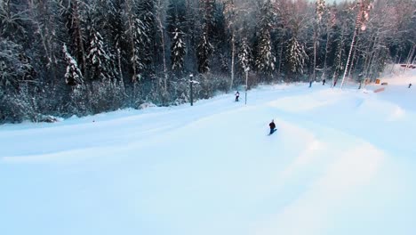 Side-aerial-view-of-a-skier-jumping-off-a-slope-in-a-terrain-park