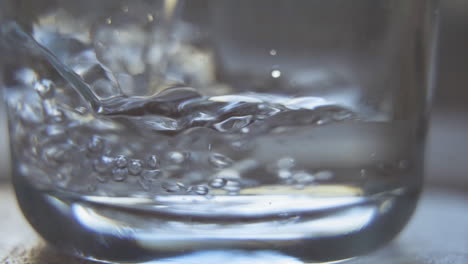 Water-bubbles-while-pouring-in-glass-up-close-in-slow-motion