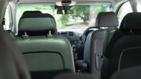 Innenraum-Eines-Luxus-Minivans-Mit-Schwarzen-Ledersitzen-Und-Cockpit-Von-Hinten-Nach-Vorne