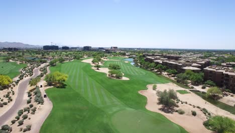 Aerial-slow-rise-from-the-empty-green-marked-with-a-white-flag-shifting-to-a-long-view-of-the-fairway-Scottsdale,-Arizona