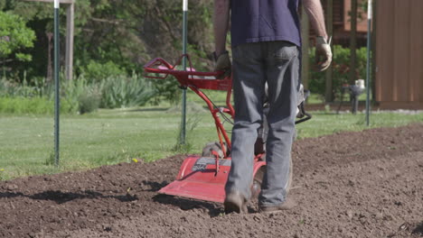 Man-uses-a-rototiller-in-the-Spring-to-prepare-for-his-garden