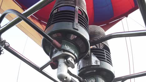 Close-Up-of-inflating-hot-air-balloon,-hand-pushing-heater-trigger,-cinematic-shot