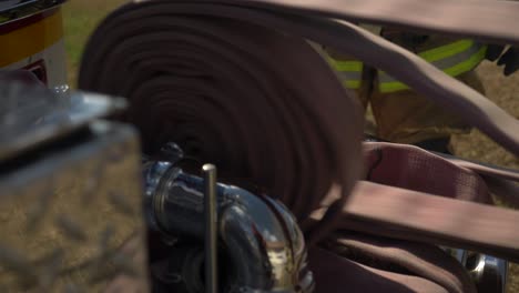Feuerwehrmann-Zieht-Einen-Feuerwehrschlauch-Aus-Einem-Feuerwehrauto,-Um-Sich-Auf-Die-Brandbekämpfung-Vorzubereiten