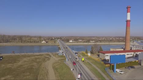 drone-shot-of-a-road-with-cars-going-to-a-bridge-eastern-europe,-Osijek,-Croatia
