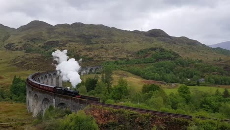 Viaducto-Ferroviario-De-Glenfinnan-En-Escocia-Con-El-Tren-De-Vapor-Jacobita-En-Verano-Con-Clima-Lluvioso