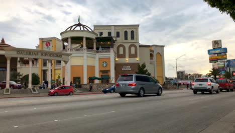 Straßenszene-Und-Verkehr-Vor-Einem-Modernen-Einkaufszentrum-Mit-Amerikanischen-Markennamen,-Tijuana,-Mexiko