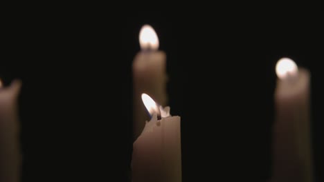 Four-white-candles-lit-then-three-are-blown-out-by-the-wind-in-slow-motion