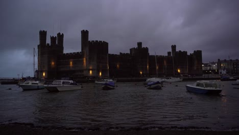 Small-boats-bobbing-in-the-harbor-in-front-of-the-historical-Caenarfon-Castle-at-dusk-in-choppy-waters-just-as-a-thunder-storm-was-about-to-start