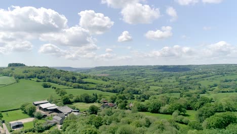 Rising-aerial-above-trees-in-a-green-Devon-countryside-farmland
