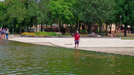 VÃ¡rosligeti-Lake-City-park,-the-over-side-of-the-park,-people-crossing-the-mini-damp,-closer-shot