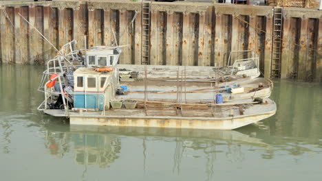 Flat-bottomed-boats-of-the-French-oyster-farmers-in-the-port-of-Saint-Trojan-les-Bain-on-the-island-of-Oleron,-water-reflection