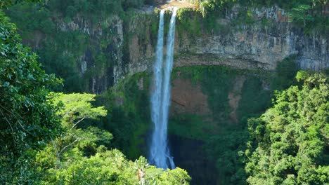 Eine-Aufnahme-Eines-Doppelstrahl-Wasserfalls,-Der-An-Einem-Sehr-Grünen-Ort-über-Eine-Natürliche-Felswand-Fällt
