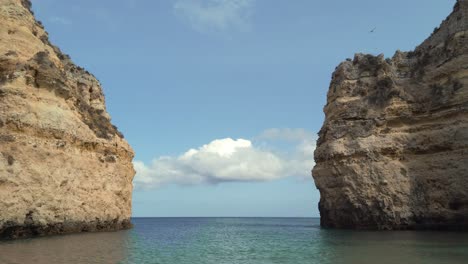 Staring-out-to-sea-beyond-limestone-sea-cliffs-in-Algarve-on-clear-day,-Portugal