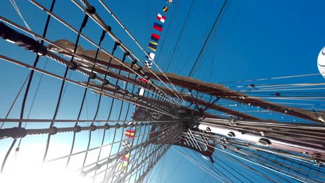 Sun-flair-shines-through-tall-ship-sailboat-ropes-and-rigging