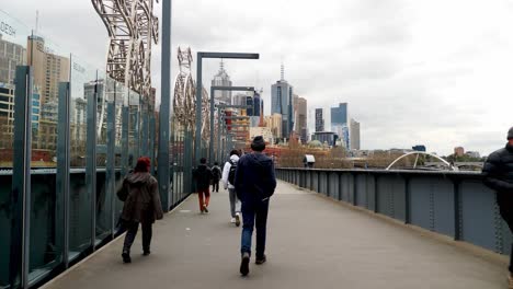 Melbourne-tourists-walking-bridge-heading-to-Flinder-Street-Station-during-daytime
