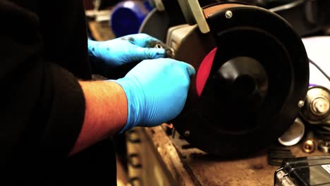 A-technician-cleans-parts-on-an-abrasive-wheel