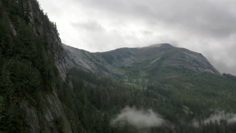 Una-Cadena-Montañosa-Brumosa-En-Un-Fiordo-De-Alaska-Revela-Profundidad,-Rocas-Y-Vegetación-Mientras-El-Paisaje-Se-Recorta-Contra-El-Cielo.