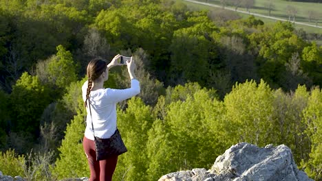 Girl-in-the-white-top-and-dark-red-leggings-taking-pictures-of-the-nature