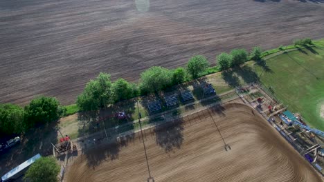Luftaufnahmen-Ziehen-Sich-Von-Einem-Brachliegenden-Feld-Zurück-Und-Zeigen-Einen-Grünen-Traktor,-Der-Die-Dirt-Horse-Arena,-Kansas,-Missouri-Pflegt