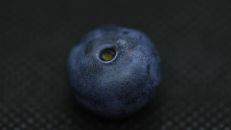 Close-up-macro-shot-of-blueberries-laying-on-dark-splashed-and-spayed-water-background-captured-water-drops-in-slow-motion
