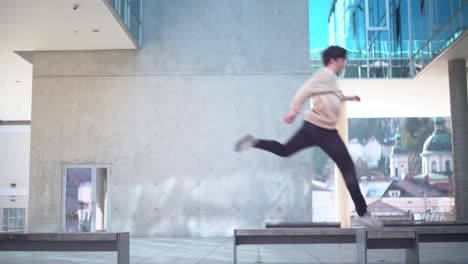 White-young-adult-doing-parkour-and-jumping-from-bench-to-bench-in-4k