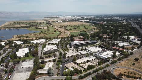 Aerial-birds-eye-view-of-corporate-tech-offices-Fly-forward-Google-campus-shoreline-amphitheater-lake