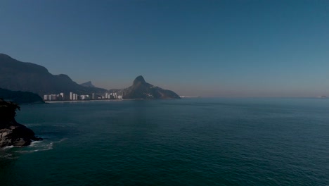 Luftaufnahme-Der-Küste-Von-Rio-De-Janeiro-Mit-Dem-Corcovado-Berg-Und-Zwei-Brudergipfeln-Im-Hintergrund,-Die-Eine-Kleine-Insel-Im-Vordergrund-Freigeben
