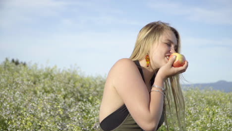 SLOMO-of-Young-Woman-Eating-an-Apple-in-a-Field-of-Flowers