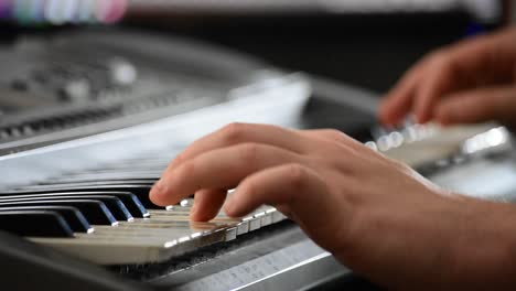 Close-up-of-hands-playing-a-keyboard-in-a-home-recording-studio