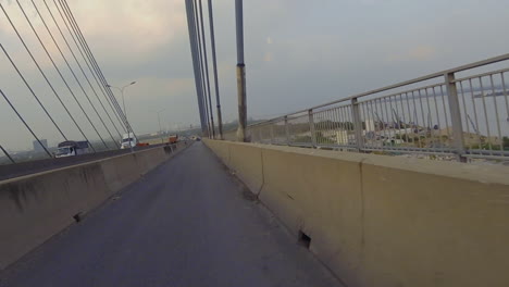 3-of-3-parts-of-crossing-the-Phu-My-Bridge-on-Motorcyle-showing-the-approach,-structure-of-the-bridge,-other-vehicles-and-shipping-on-the-river-below