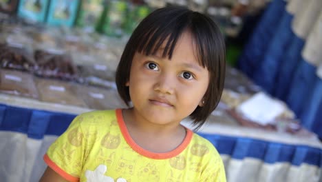 Rotating-shot-of-an-adorable-little-Indonesian-girl-smiling-at-the-camera-in-Bali,-Indonesia