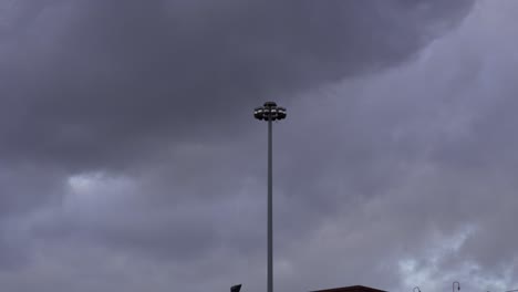 Slow-Motion:-The-Storm-is-approaching,-a-light-pole-in-the-middle-of-the-frame-is-shaking-from-the-intense-wind