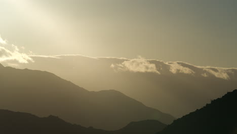 Time-lapse-of-Sun-Setting-Behind-Clouds-and-Mountains