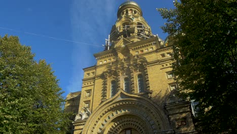 View-of-orthodox-St-Nicholas-Naval-Cathedral-golden-domes-and-crosses-on-blue-sky-in-sunny-autumn-day-at-Karosta,-Liepaja,-tilt-up-wide-shot