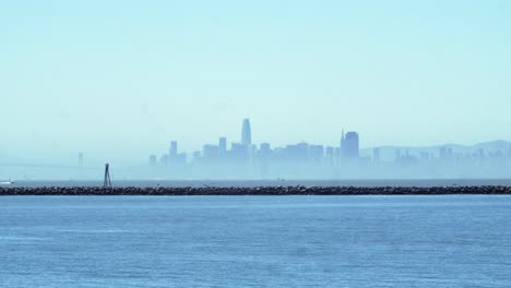 Zeitraffer-Der-Skyline-Der-Innenstadt-Von-San-Francisco-Mit-Bay-Bridge-Und-Segelbooten-An-Einem-Sonnigen-Tag