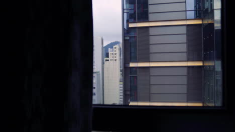 Die-Vorhänge-öffnen-Sich-Langsam-Und-Geben-Den-Blick-Auf-Die-Mit-Hohen-Gebäuden-übersäte-Innenstadt-Von-Hongkong-Frei