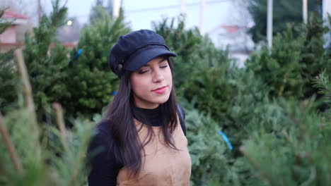 A-hispanic-woman-in-the-holiday-spirit-shopping-for-festive-Christmas-trees