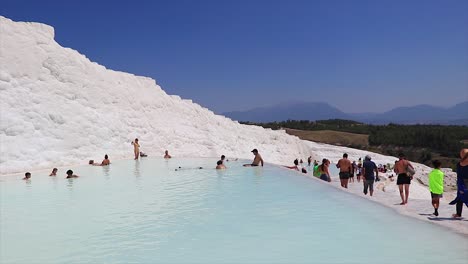 Natural-pool-with-water-and-people-swimming-in-it-at-the-natural-landmark-Pamukkale-in-Turkey