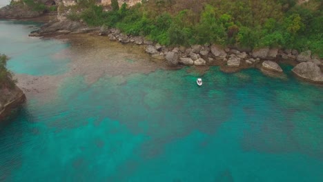 Pull-Back-Aerial-View-on-Solitary-Boat-Anchored-in-Tropical-Lagoon-of-Exotic-Island