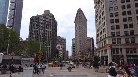 Establishing-shot-of-Flatiron-Building-at-Madison-Square-Park-Intersection-of-5th-Avenue-and-Broadway-on-a-sunny-summer-day-in-New-York-City,-USA
