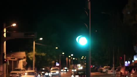 Traffic-at-night-stopping-at-a-stop-light-waiting-for-it-to-turn-green
