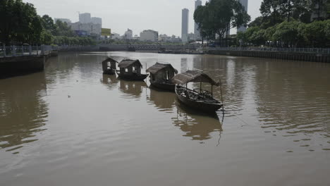 aerial-pushing-in-shot-of-a-row-of-old-traditional-style-river-fishing-boats-in-a-Hoang-Sa-canal-in-Binh-Thanh-district-of-Ho-Chi-Minh-City-or-Saigon-Vietnam