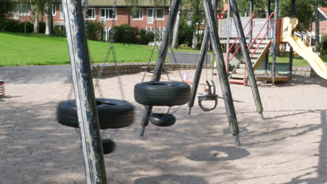 an-Empty-swing-made-up-of-used-car-tires-swinging-on-a-playground-in-the-town-of-Partille-outside-of-Gothenburg,-Sweden